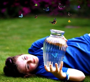 Freedom of Movement: photo credit - Carnie Lewis girl lying in grass catching butterflies