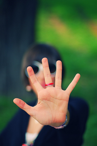 Stop: photo credit - Alessandro Pautasso woman holding up left hand in STOP gesture